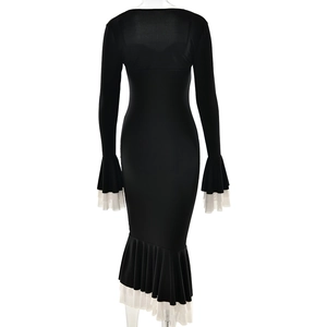 Detail view of the black slim-fit dress back featuring ruffled fish-tail hem with white trim