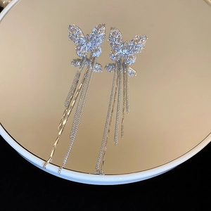 Detailed macro shot of silver butterfly tassel earrings with sparkling cubic zirconia inlay