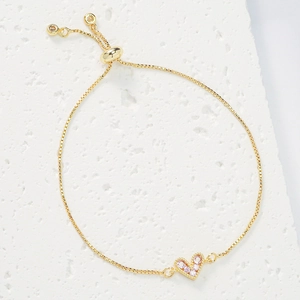 Detailed macro of gold heart pendant with pink cubic zirconia and adjustable box chain