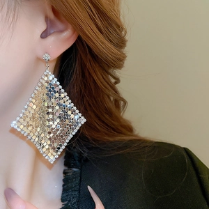 Detail view of large diamond-shaped silver mesh earrings with sparkling sequins