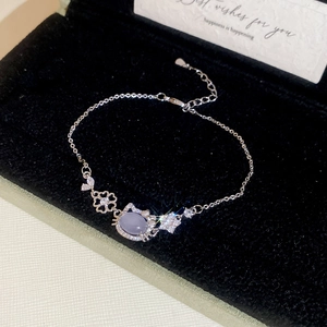 Detail view of silver Hello Kitty charm bracelet with purple gemstone in black velvet box