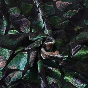 Macro detail of textured floral velvet fabric with mesh backing and elegant drape