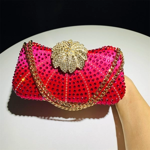 Detail of rose red rhinestone evening bag with golden floral clasp and chain strap