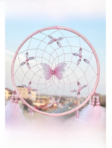 Macro shot of pink handmade dreamcatcher with crystal butterflies and soft feathers