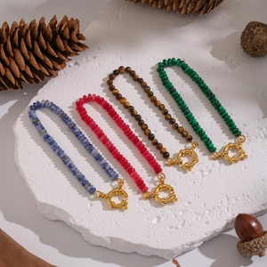 Detail of beaded malachite and tiger eye bracelets with golden OT clasps on stone