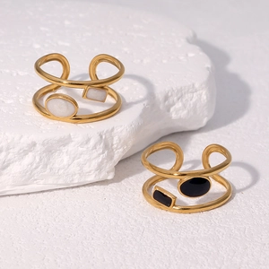 Detail of 18k gold plated stainless steel open rings with black and white inlays