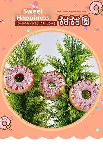 Detail view of pink and gold donut Christmas ornaments hanging on green pine branches