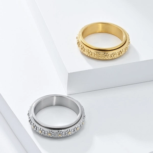 Detail of spinning daisy rings in gold and silver on minimalist geometric pedestals