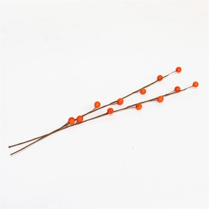 Close-up of artificial orange berries with brown branches for DIY spring home decor