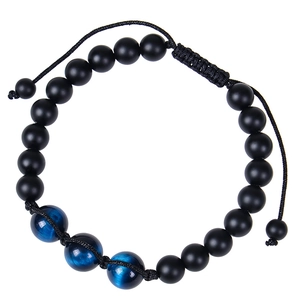 Close-up of matte black beads and blue cat eye stones on an adjustable braided bracelet