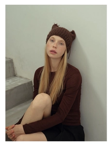Close-up of brown knit cat ear beanie featuring hollow textures and cute bow details