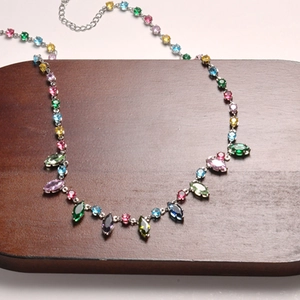 Macro shot of colorful oval crystals and diamonds on 18K gold-plated chain necklace