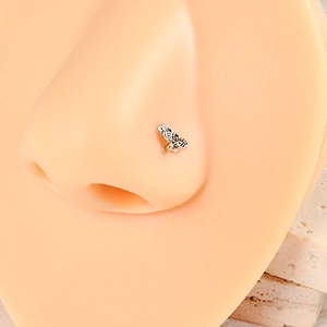 Close-up of vintage silver butterfly nose stud on model showing intricate texture