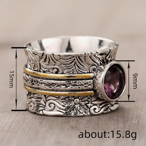 Vintage two-tone wide band ring featuring floral engraving and a purple round gemstone