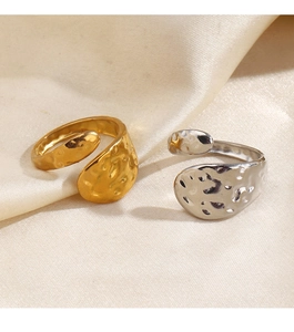 Détail de bagues martelées or et argent présentées sur un fond de tissu en soie beige