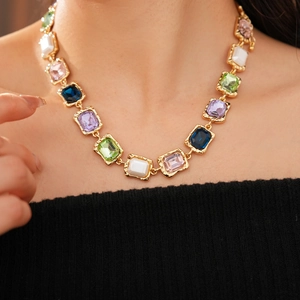Close-up of vintage gold necklace featuring vibrant multicolored rectangular gemstones