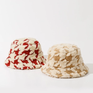 Close-up of plush houndstooth bucket hats in red and brown with soft faux fur texture