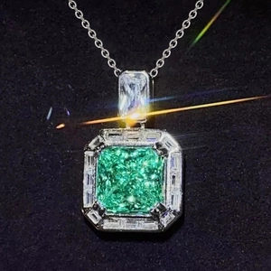 Luxurious emerald cut green gemstone necklace with silver chain on black background