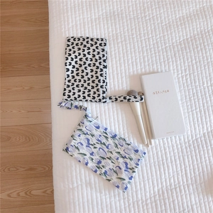 Detail of quilted floral makeup bags with handles and matching makeup brushes