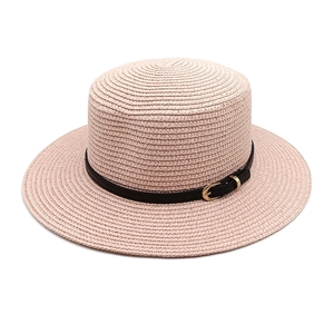 Detail of light pink woven straw hat featuring a black leather band and gold buckle