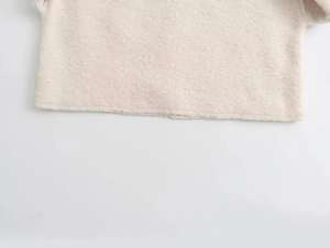 Close-up of the oatmeal fleece sweater hem showing soft knit texture and stitching details