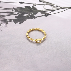 Macro detail of gold link chain ring featuring a square zircon and S925 hallmark