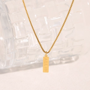 Detailed macro shot of 18K gold plated rectangular pendant engraved with ALL IN text