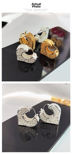Detail showing gold and silver heart hoop earrings with textured pebble pattern
