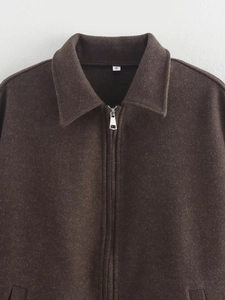 Detail of dark brown wool jacket featuring fine plush texture and a metallic zipper