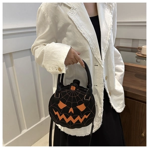 Detail of a round Halloween pumpkin handbag with orange spider web and pumpkin face design