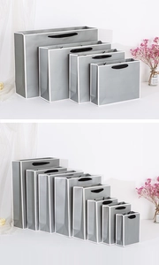 Detailed size comparison of grey paper gift bags with white piping and black handles