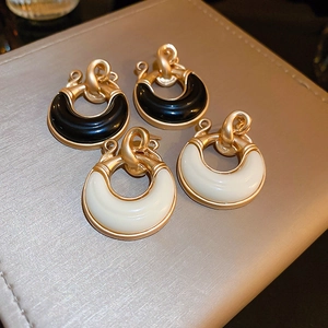 Detail shot of vintage resin geometric C-shaped hoop earrings with gold knot design