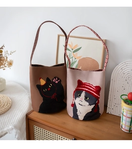 Detailed view of canvas bucket bags featuring cute cartoon cat patterns in pink and brown