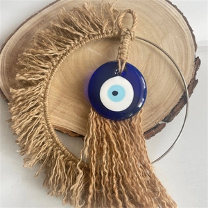 Bohemian handmade jute woven evil eye wall decor with fringe and blue glass bead accent