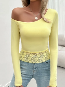Detail of yellow one-shoulder knitted top with delicate lace hem and ribbed texture