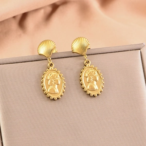 Vintage gold seashell earrings with oval portrait relief pendant on jewelry box