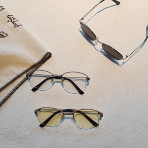Flat lay of vintage metal frame glasses in dark grey, clear and yellow lens options