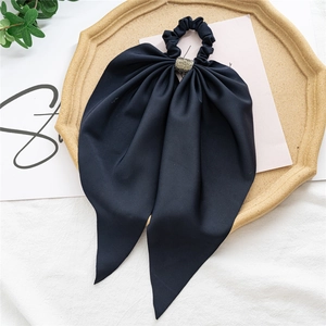 Detail of a black chiffon hair scrunchie with sparkling rhinestones and a long ribbon bow