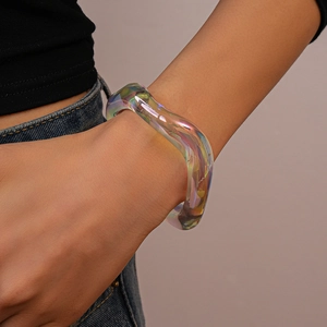 Close-up of wavy iridescent acrylic bangle showing colorful holographic reflections