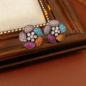 Close-up of vintage flower earrings with multi-color rhinestones on a retro leather base