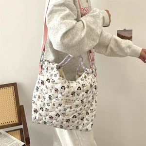 Sac fourre-tout matelassé avec imprimé cartoon porté à l'épaule dans un décor cosy