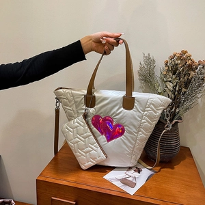 Detail der weißen gesteppten Puffer-Tasche mit rosa Herzen und kleiner Zubehörtasche