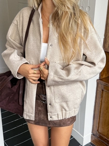 Detail of beige button-up long sleeve vest jacket with pockets on a lifestyle model