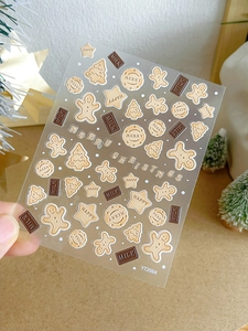 Close-up of 3D embossed gingerbread man nail stickers with Christmas tree and stars