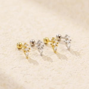 Macro shot of gold and silver S925 sterling silver waterdrop stud earrings with zircons