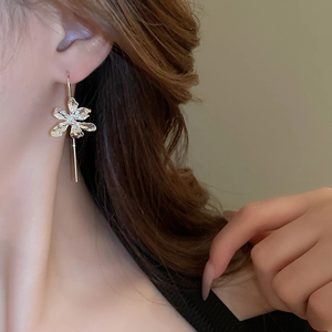 Close-up of French iris flower earring with a sleek silver tassel on a model side view