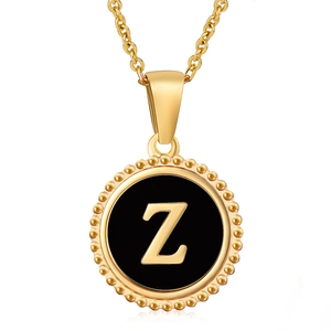 Close-up of golden letter Z pendant with black enamel inlay and beaded edge detail