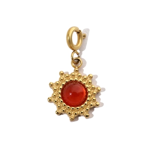 Macro view of gold sunflower pendant with red central gemstone and textured petals