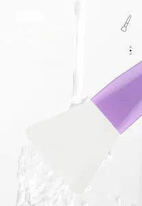 Detailed view of rinsing soft silicone face mask brush head under clean water flow
