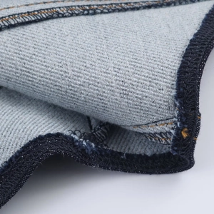 Macro detail of high-density denim fabric with reinforced seams and indigo twill texture